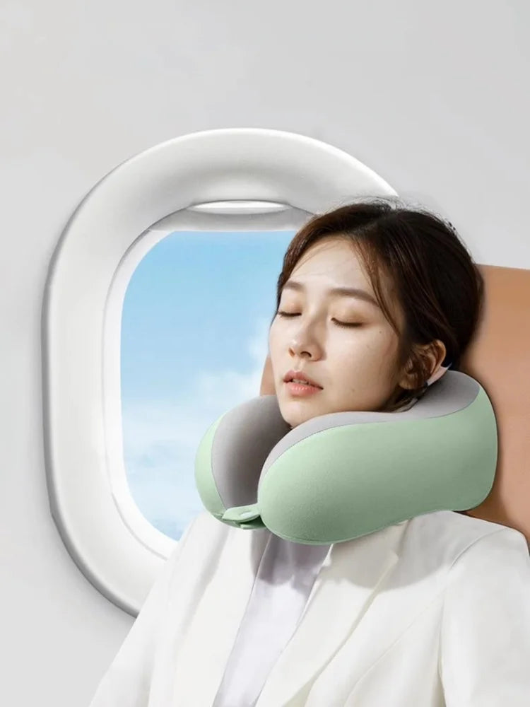 Woman using a green neck pillow in front of an airplane window