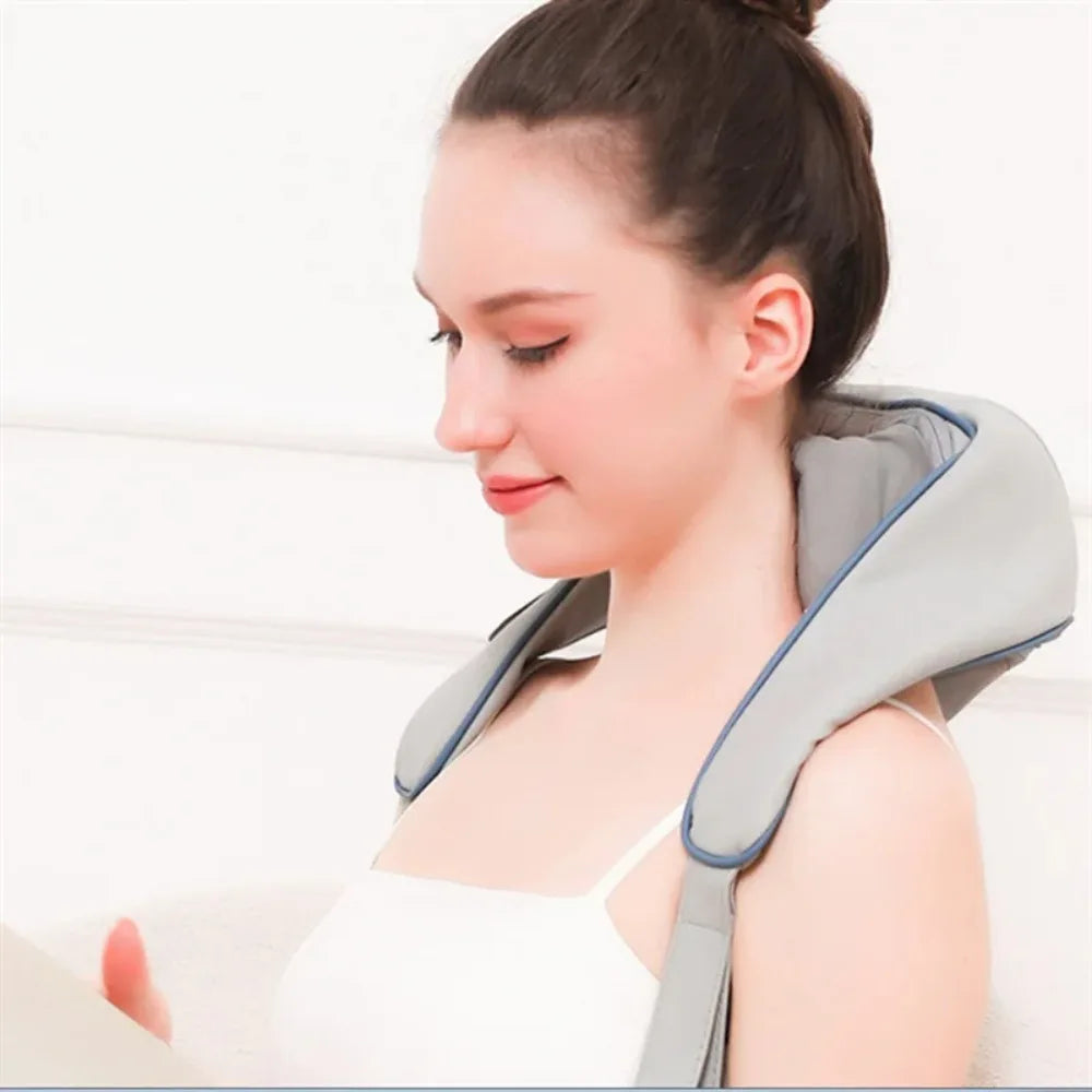 Woman using a gray neck and shoulder massager against a white background,آلة التدليك