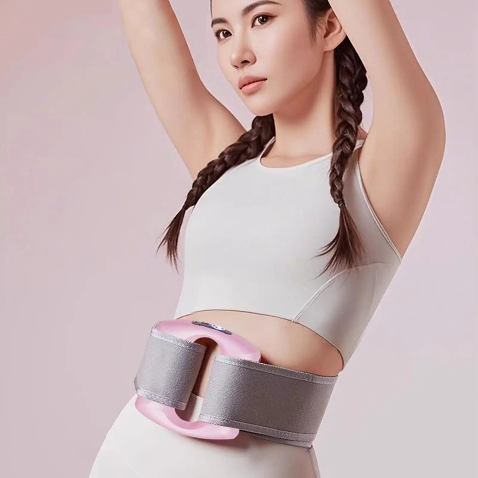 Woman wearing a waist trainer with pink and gray design on a light pink background. مدلك الجسم